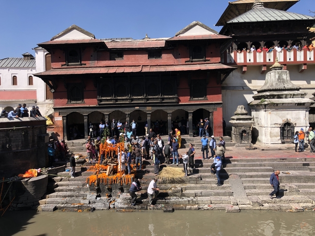       Crowded area near temple with a gathering of people.
  