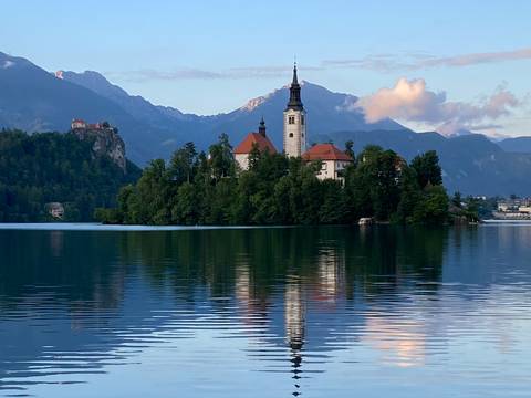 Scenic view of a church and castle with a reflection on the lake.