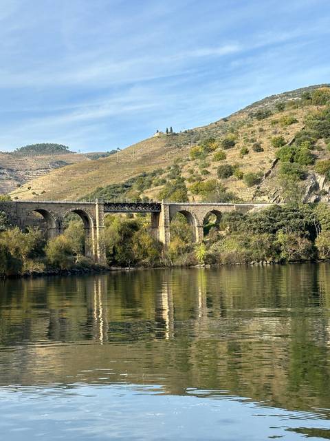 Bridge over a river with hills in the background.