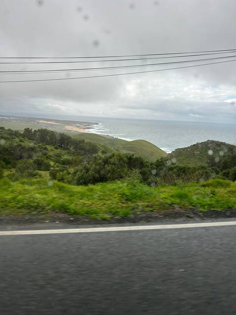 Coastal road with green hills and sea.