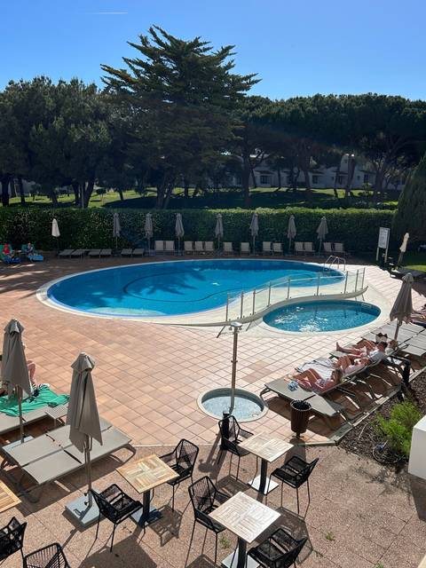 Swimming pool in a resort with trees around.