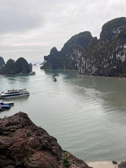 Dramatic view of karst hills and waterway dotted with boats.