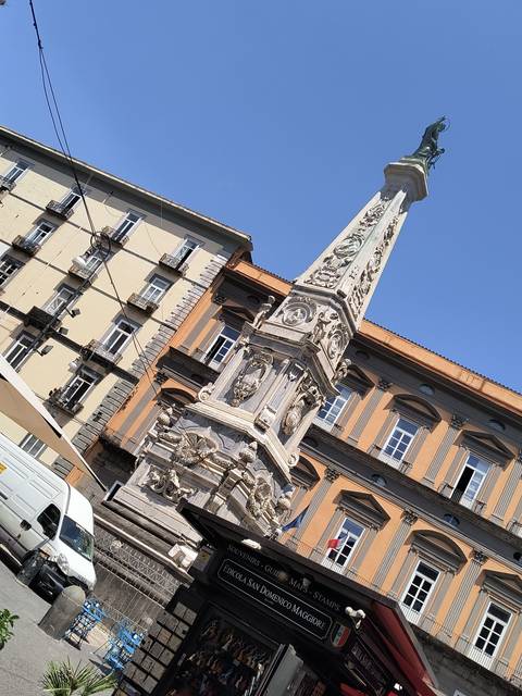 Historic monument and street with people.