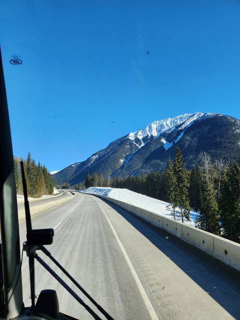 Mountain road with snow and trees.