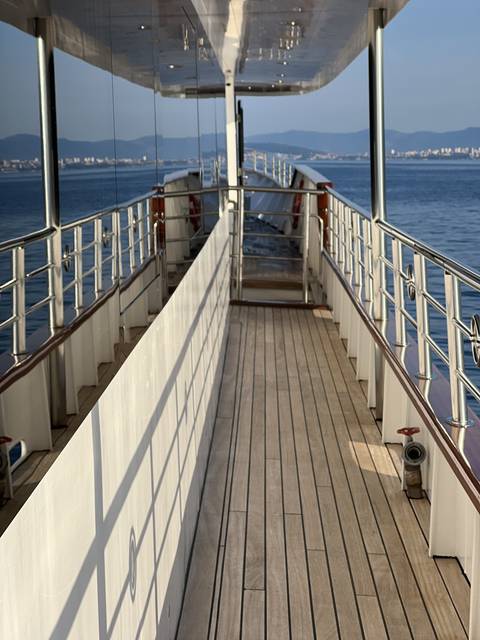 Outdoor deck area of a ship with railings and ocean view.