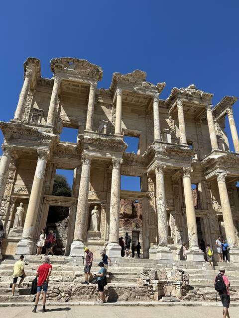       Ancient ruins with tourists exploring.
  