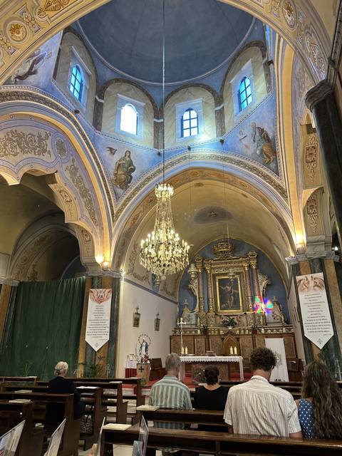       Interior of a church with people seated.
  