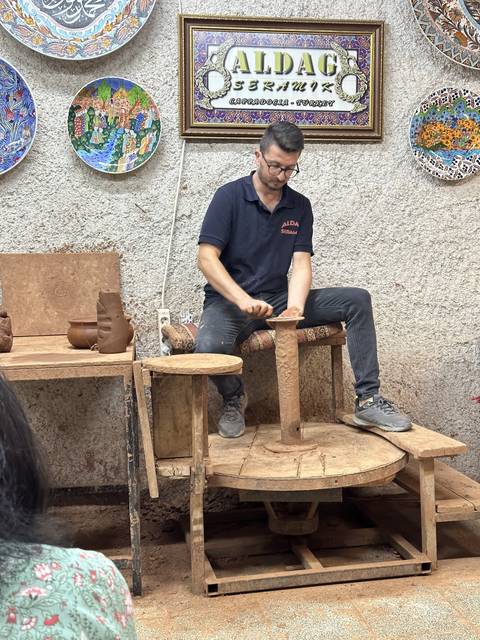       Man demonstrating pottery craft.
  
