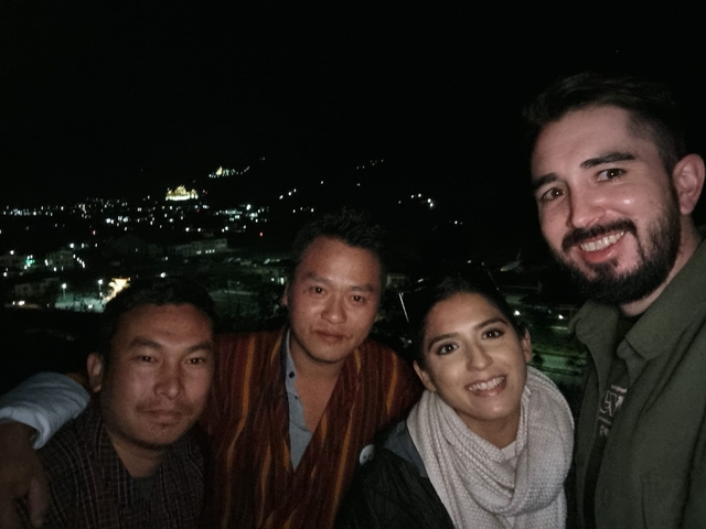       Group taking a night portrait with city lights in the background.
  