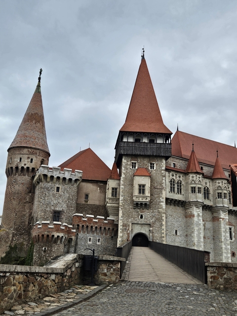       Gothic castle with stone walls and red-tiled roof.
  