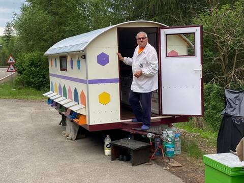       Vendor standing by a mobile shop trailer.
  
