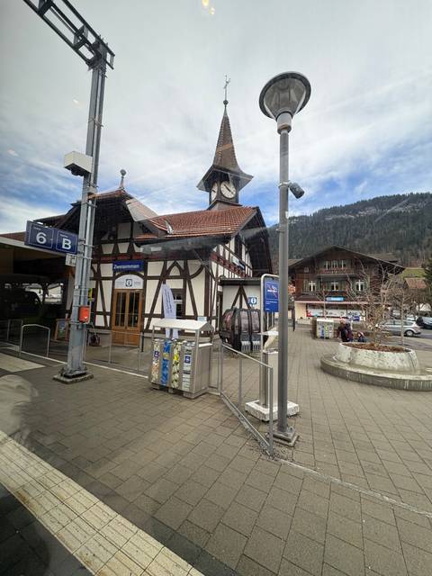 Train station with a timber-frame building in a mountainous area.