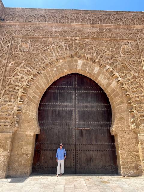       Person standing next to a large wooden door.
  