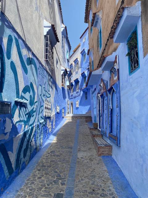       Colorful blue alleyway with traditional decor.
  