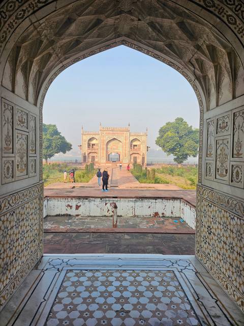 Archway view with distant building and people walking.