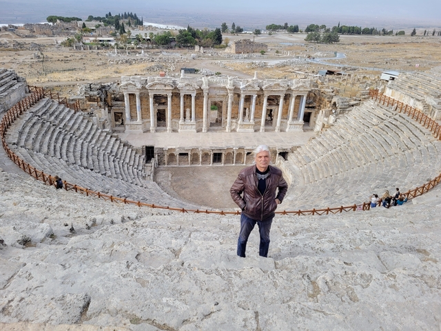 Person standing in an ancient amphitheater.