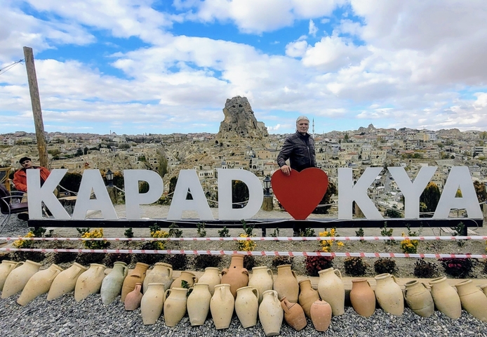 People posing with a large decorative sign.