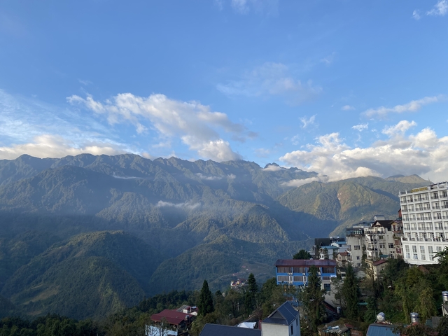 Mountain range with green valleys and scattered buildings.