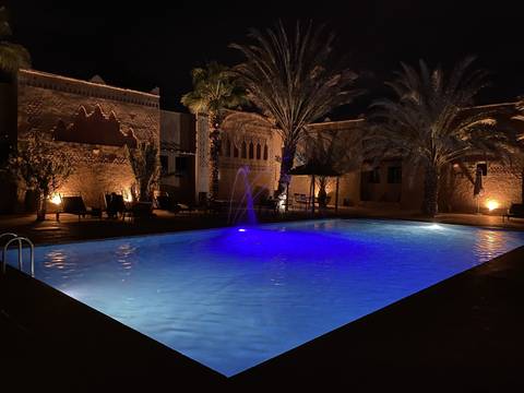 Illuminated pool in a courtyard at night.