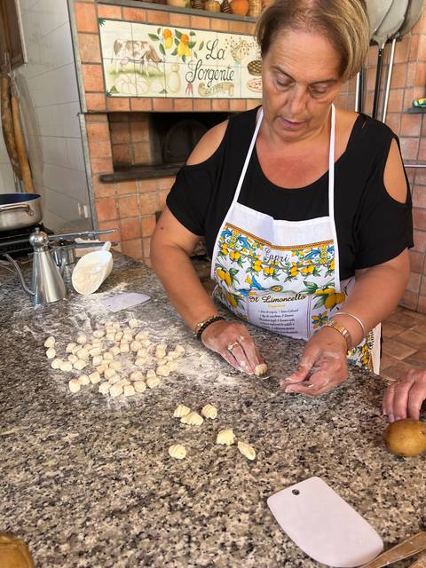 Woman preparing dough on a counter.