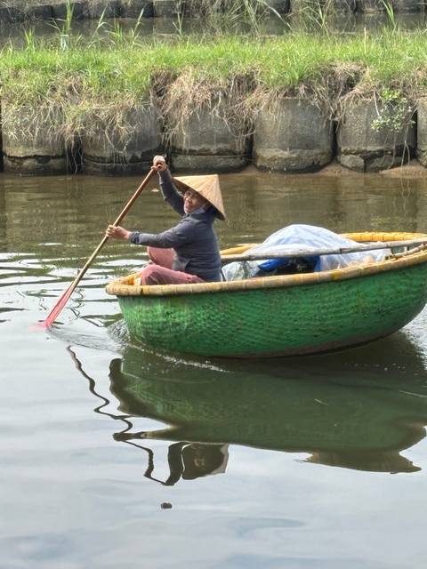       Person paddling a boat on a calm river.
  