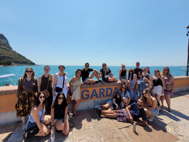       Group photo by Lake Garda with sign
  