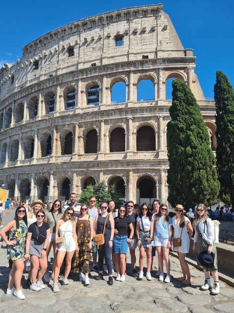       Group photo in front of the Colosseum in Rome
  