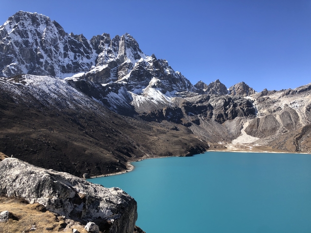       Blue glacial lake surrounded by mountains
  