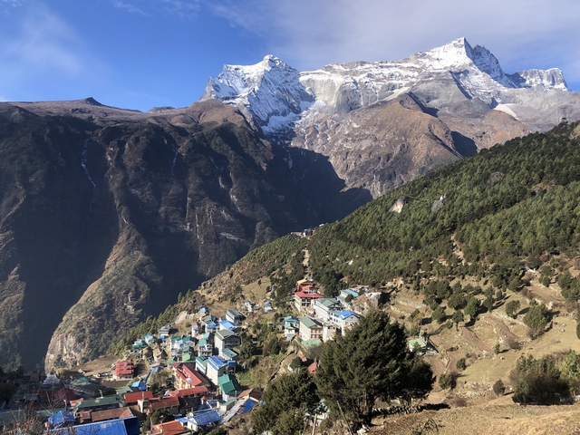       Mountain village with snow-capped peaks in the background
  