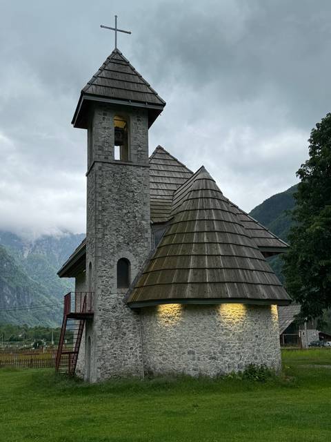 A church with a bell tower in a mountain setting.