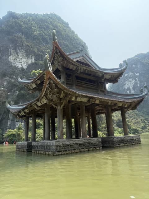       Traditional wooden building partially submerged in water.
  