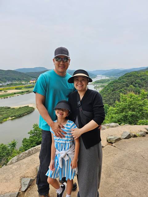Family posing outdoors with a natural backdrop.