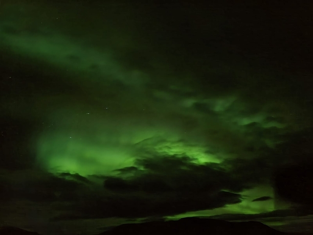 Green aurora borealis in the night sky.