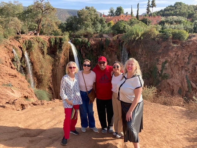 Group of people in front of waterfalls.