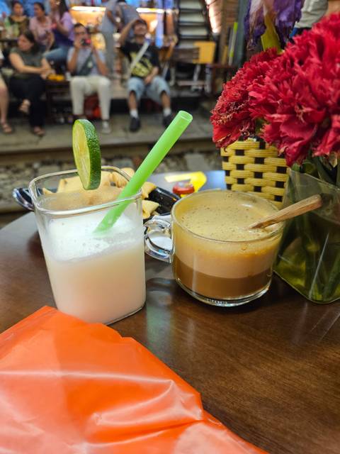       Two drinks served on a table with decorative flowers.
  
