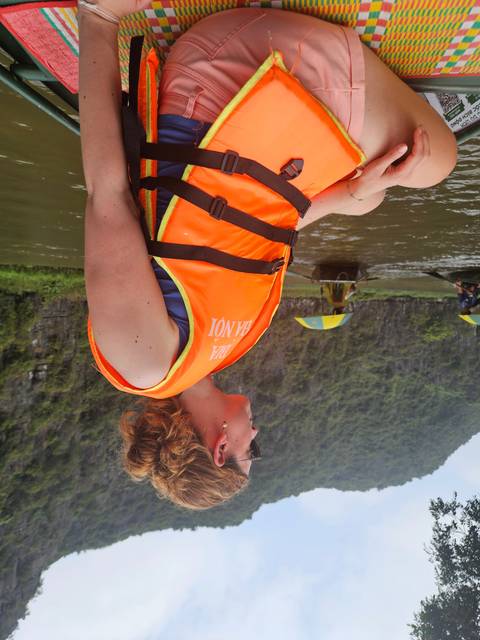       Person in a life jacket relaxing on a boat.
  
