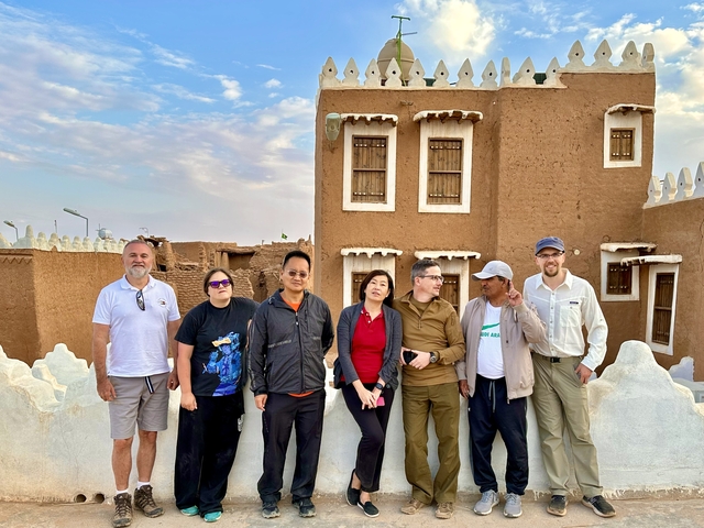 Group of people in front of traditional architecture.