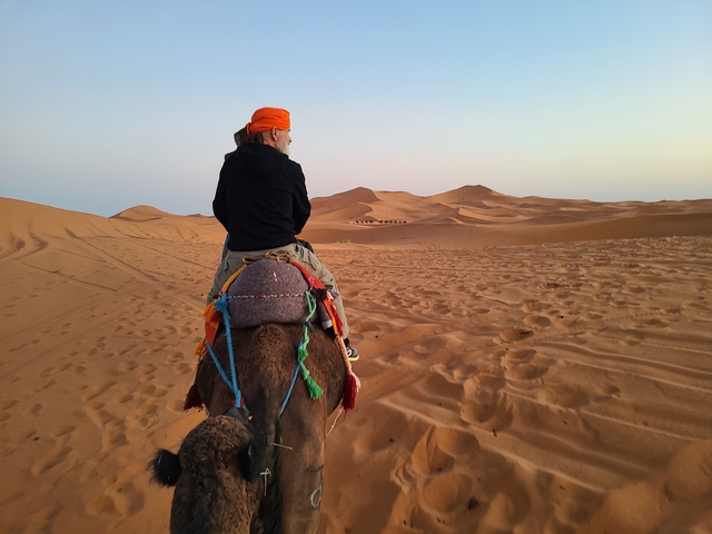 A person riding a camel in the desert.