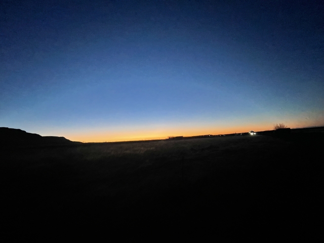 Sunset over a landscape with dark shadows.