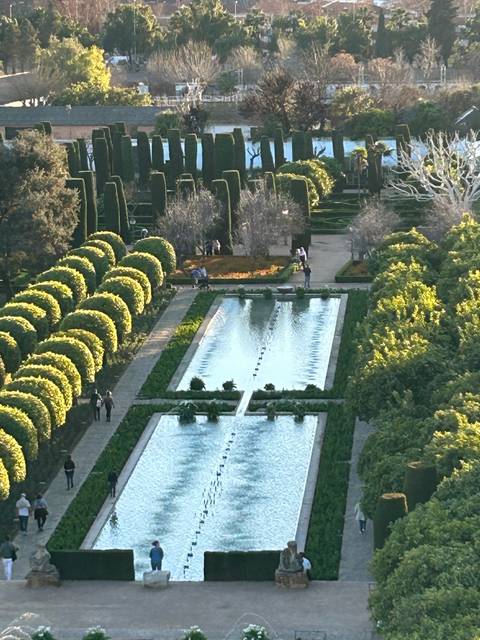 Formal garden with geometric patterns and fountains.