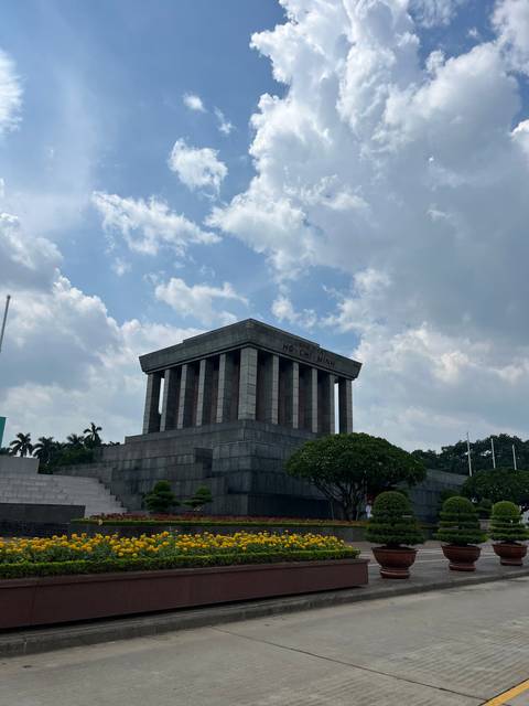 Mausoleum with clouds and flowers around.