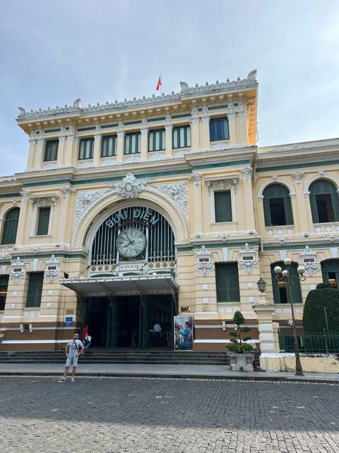 Two people in front of a large, ornate building.