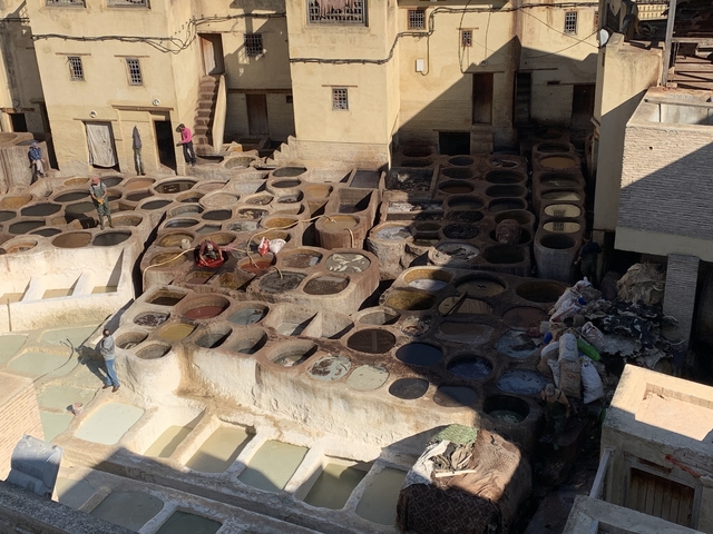 Workers at a traditional tannery with multiple dye pits.