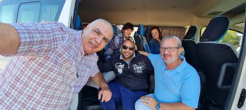       Group of people taking a selfie outside a vehicle.
  