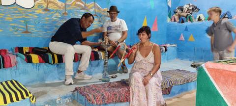 People smoking shisha in a colorful indoor setting.
