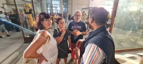 Tourists in a museum with a guide explaining.