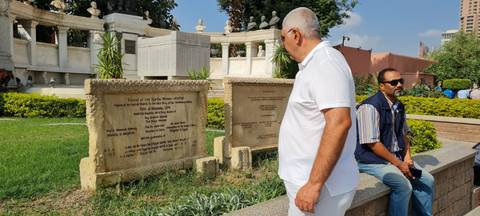 People sitting and observing outdoor plaques.