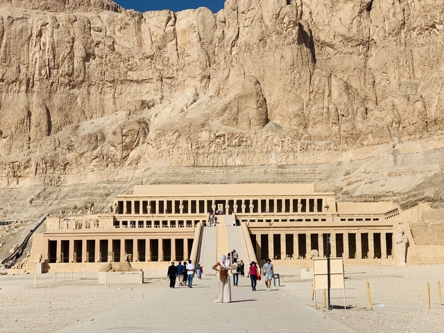 Temple ruins with tourists exploring the area.