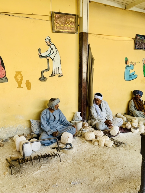       Two men sitting on the ground with crafts.
  