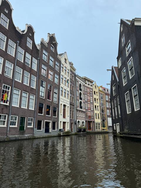 Tall, slender canal houses reflected in the water.